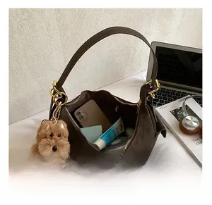 Spacious interior of dark brown suede hobo bag showing capacity for phone and cosmetics