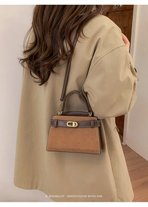 Detail of caramel suede crossbody bag with CD metal buckle and white stitching accents
