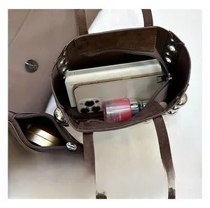 Détail de la grande capacité intérieure du sac cabas en daim marron avec pochette zippée