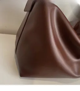 Close-up of soft dark brown pebble grain leather texture on a stylish tote bag