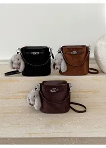 Chic bucket bags in black and brown suede with metal locks and cute bunny charms