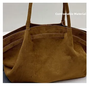 Detail view of the soft brown suede fabric and sturdy handle on this minimalist tote bag