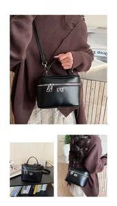 Detailed view of the black leather box bag with silver twist lock and top handle