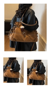 Detail of tan leather tote bag with white contrast stitching and plush glove charm