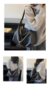 Close-up of black minimalist tote bag with smooth texture and metal strap adjustment buckle