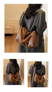 Macro detail of brown leather tote bag showing soft matte texture and minimalist design