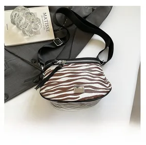 Detailansicht der Zebra-Satteltasche mit breitem schwarzem Gurt und silbernem Metalllogo