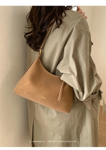 Brown minimalist retro hobo shoulder bag shown on model with clear logo detail