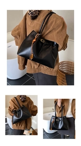 Détails du sac cabas noir avec texture plissée, gland en perles de bois et boucle dorée