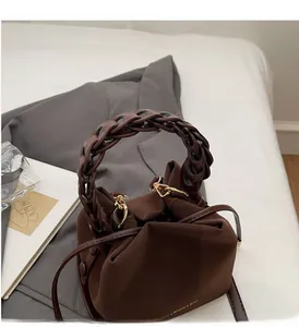 Macro view of woven handle and pleated texture on dark brown fashion bucket bag