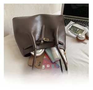 Vue macro de l'intérieur spacieux du cabas marron rempli d'objets essentiels du quotidien