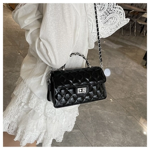 Détail du sac matelassé noir classique avec fermoir rotatif argenté et bandoulière
