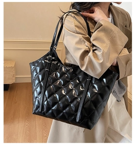 Close-up of quilted black patent leather tote bag with elegant diamond stitch pattern