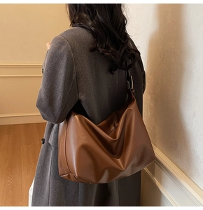 Detail of vintage brown leather tote bag showing hobo slouch style and shoulder strap buckle