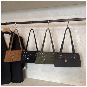 Detail of vintage suede shoulder bags with metal eyelets and heart-shaped charms