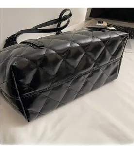 Detail of black quilted leather texture and stitching on this stylish tote bag