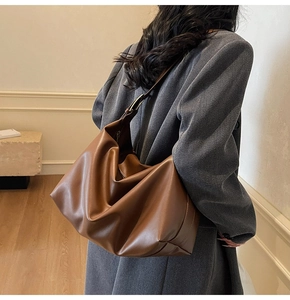 Detailed view of brown hobo shoulder bag featuring soft texture and metal buckle detail