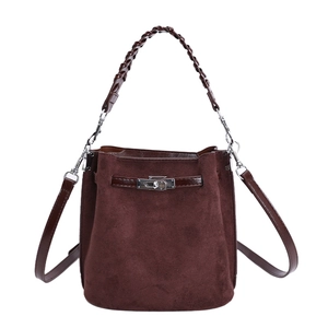 Minimalist dark brown suede bucket bag with woven handle and elegant metal buckle closure
