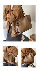 Detail of large brown faux leather tote bag with elegant tassel charm and fine texture