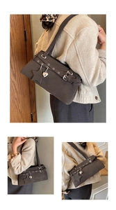 Detail einer dunkelbraunen Wildleder-Schultertasche mit Ösen und Stern-Anhänger