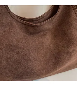 Detail of dark brown suede tote bag featuring premium soft texture and fine stitching