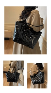 Macro detail of glossy black quilted tote bag with diamond stitching and leather texture