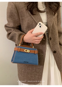Détail du sac à main en denim bleu et cuir marron avec fermoir rotatif doré PANTOR
