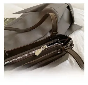 Close-up of premium light gold zipper and matte brown leather texture on handbag