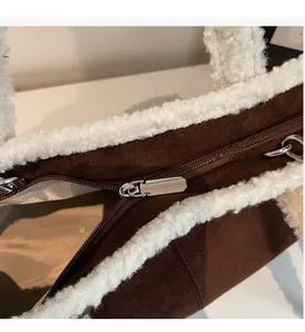 Detail shot of smooth silver metal zipper and soft white faux shearling trim on tote bag