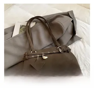 Detail of dark brown retro shoulder bag with star and heart metal charms and belt strap