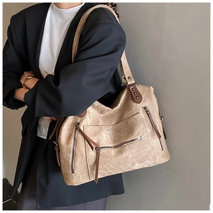 Détail du grand sac cabas kaki avec poches zippées multiples et matériau texturé