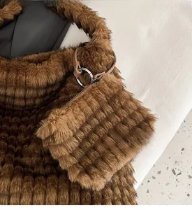 Detail of plush brown bucket bag showing fuzzy vertical texture and mini pendant charm