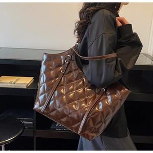 Close-up of a large quilted tote bag in dark brown glossy finish with diamond stitching