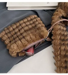 Close-up of small brown faux fur accessory bag with zipper and lipstick storage