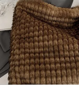 Close-up of brown faux fur fabric with a distinctive grid pattern and soft texture