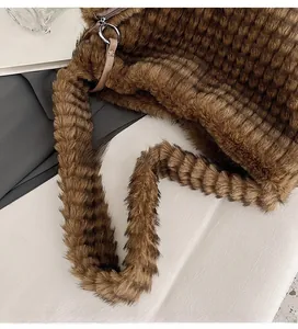 Detail of plush brown tote bag featuring horizontal striped faux fur and long handle