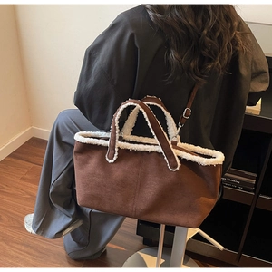 Detailed view of brown suede tote bag with white faux fur trim on model shoulder