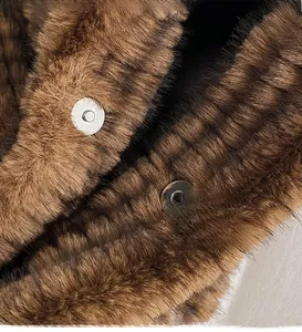 Close-up of silver magnetic hardware buckle on luxurious brown faux fur shoulder bag