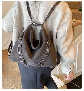 Detailed view of matte brown leather vintage tote bag with dual zipper exterior pockets