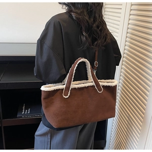 Détail du cabas en daim marron avec bordure en laine d'agneau blanche et bandoulière