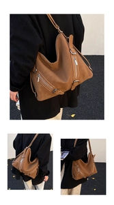 Close-up of caramel brown retro suede tote bag with vintage metal zippers and buckles