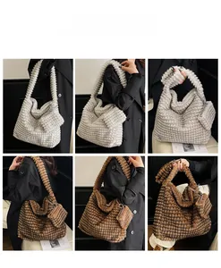 Detail view of large plush tote bag with grid texture and matching mini zipper pouch