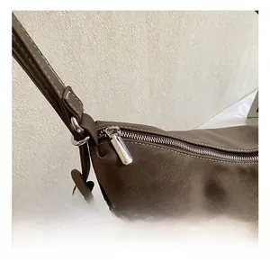 Detailed view of silver hardware accents and precision stitching on brown leather tote bag