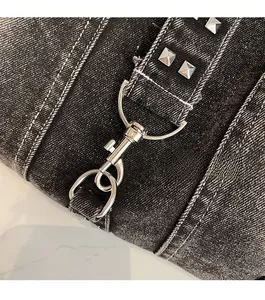 Detailed macro view of silver twist lock and square rivets on washed denim tote bag