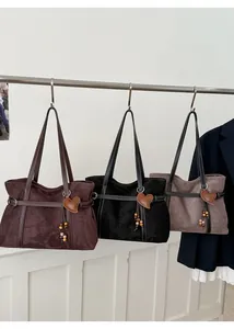 Multiple stylish tote bags with heart charms and ethnic bead details hanging in a row