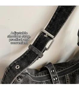 Detail of adjustable washed denim strap with silver metal buckle and eyelets on tote bag