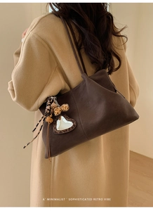 Detailed view of deep brown vintage tote bag featuring leopard heart and puff bag charms