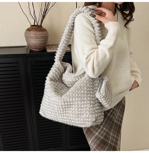Detail of grey plush cloud tote bag showing thick strap and matching small zipper pouch