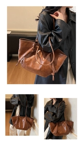 Detail view of large brown vintage tote bag with drawstring sides and leather texture