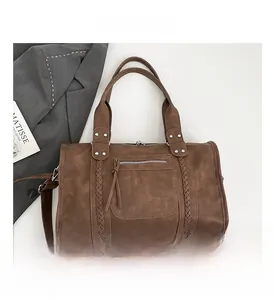 Detailed close-up of brown vintage travel bag showing side woven texture and rivets
